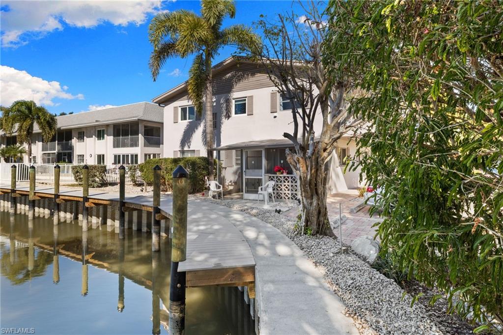 1686 Blue Point Avenue, Unit A1 Naples, FL 34102 - Photo 29 of 38 a front view of a house with garden