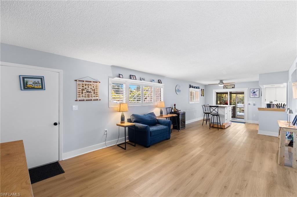 1686 Blue Point Avenue, Unit A1 Naples, FL 34102 - Photo 3 of 38 a living room with furniture and a wooden floor