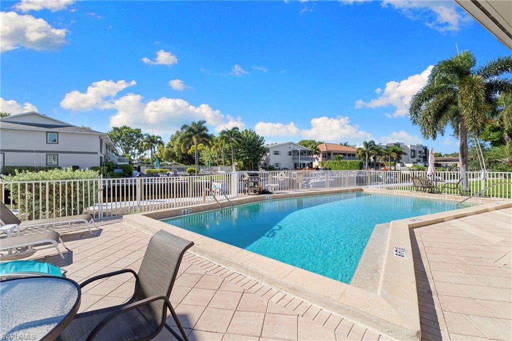 1686 Blue Point Avenue, Unit A1 Naples, FL 34102 - Photo 31 of 38 a view of swimming pool with outdoor seating