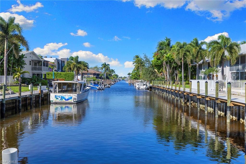 1686 Blue Point Avenue, Unit A1 Naples, FL 34102 - Photo 33 of 38 a balcony with wooden floor table and chairs