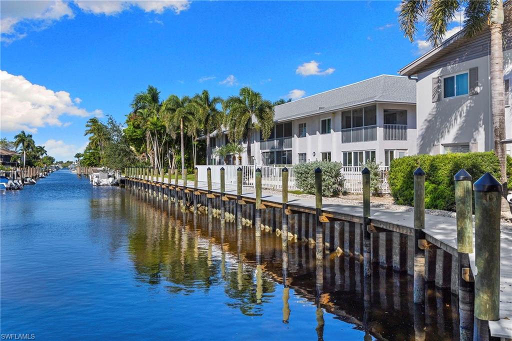 1686 Blue Point Avenue, Unit A1 Naples, FL 34102 - Photo 34 of 38 a balcony with wooden floor and outdoor seating