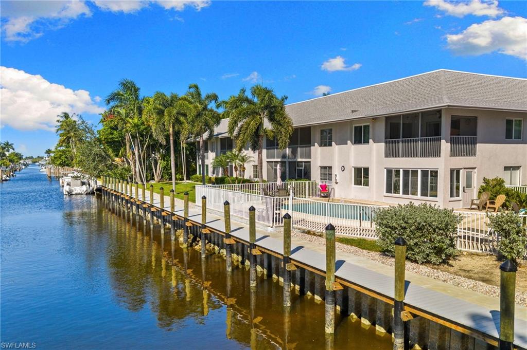 1686 Blue Point Avenue, Unit A1 Naples, FL 34102 - Photo 37 of 38 a view of a house with wooden stairs and a small yard
