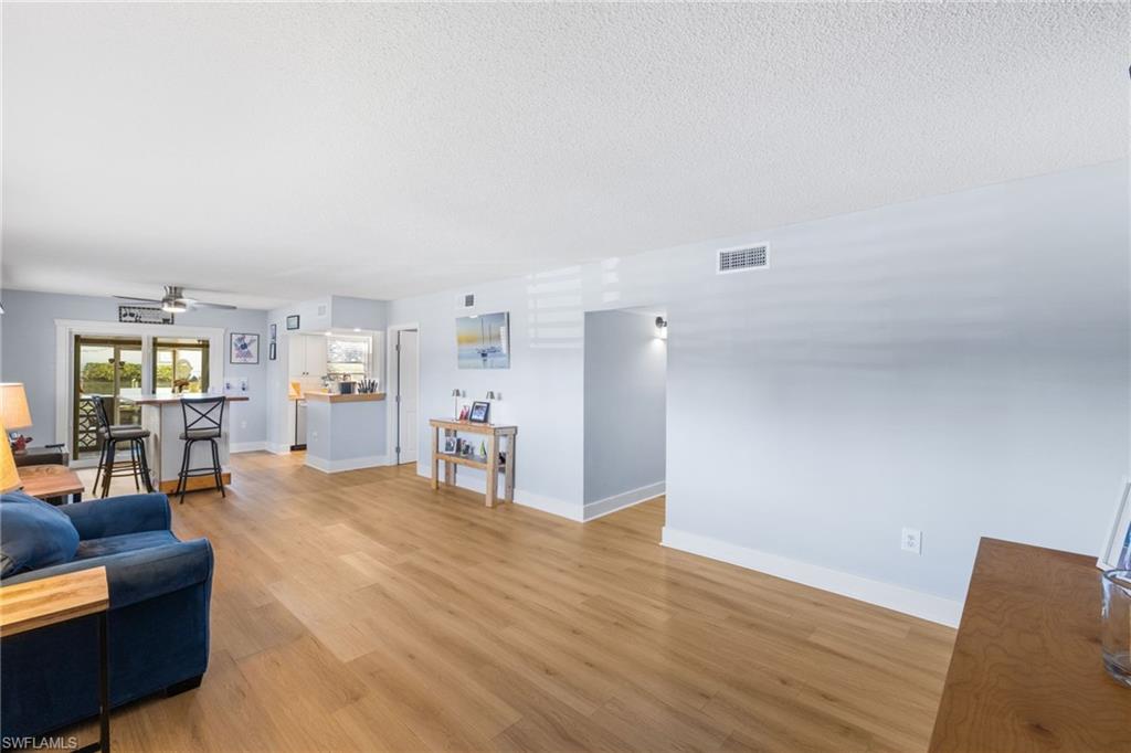 1686 Blue Point Avenue, Unit A1 Naples, FL 34102 - Photo 4 of 38 a view of a livingroom with furniture and wooden floor