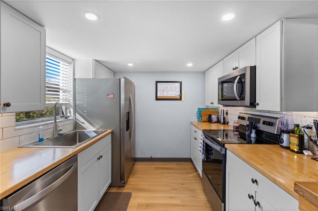 1686 Blue Point Avenue, Unit A1 Naples, FL 34102 - Photo 6 of 38 a kitchen that has a sink and a stove in it