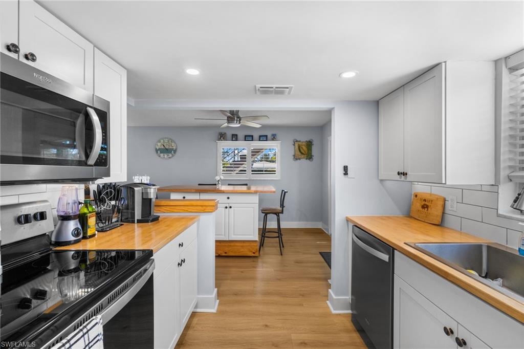 1686 Blue Point Avenue, Unit A1 Naples, FL 34102 - Photo 7 of 38 a kitchen with stainless steel appliances a stove sink and cabinets
