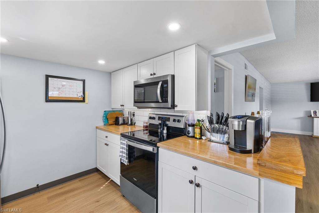 1686 Blue Point Avenue, Unit A1 Naples, FL 34102 - Photo 9 of 38 a kitchen with appliances a sink and cabinets