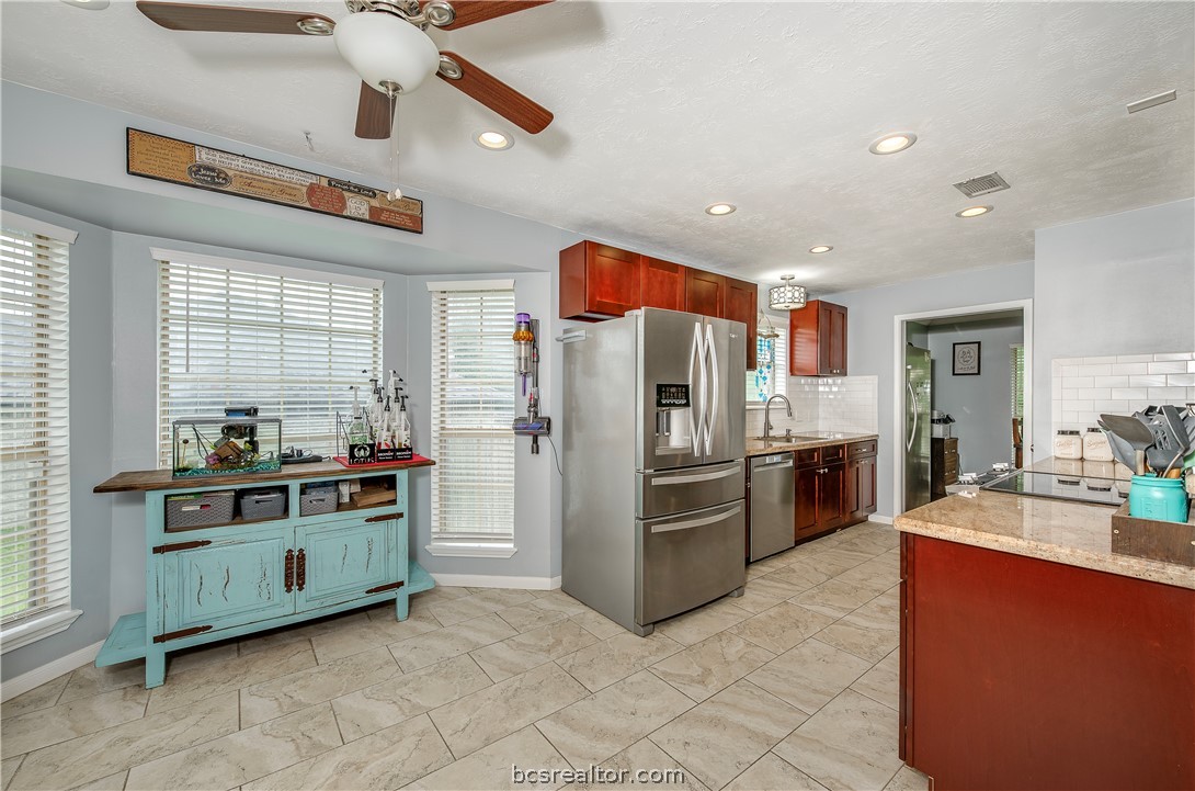 2009 Cobblestone Lane Bryan, TX 77807 - Photo 9 of 23 a kitchen with stainless steel appliances kitchen island granite countertop a refrigerator and a stove