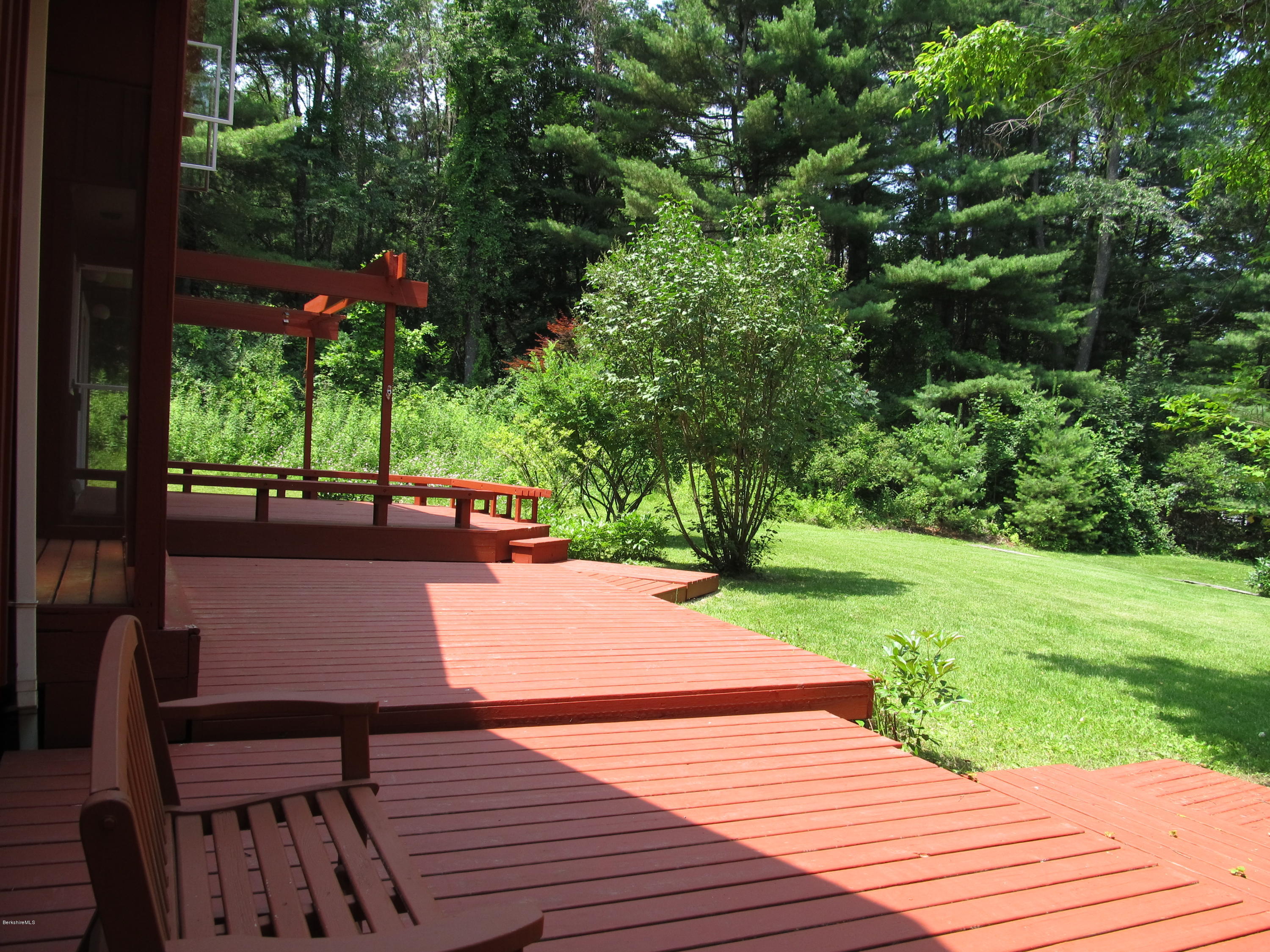 41 Pine Knoll Road Lenox, MA 01240 - Photo 22 of 37 a view of a patio with dining table and chairs with wooden floor and fence