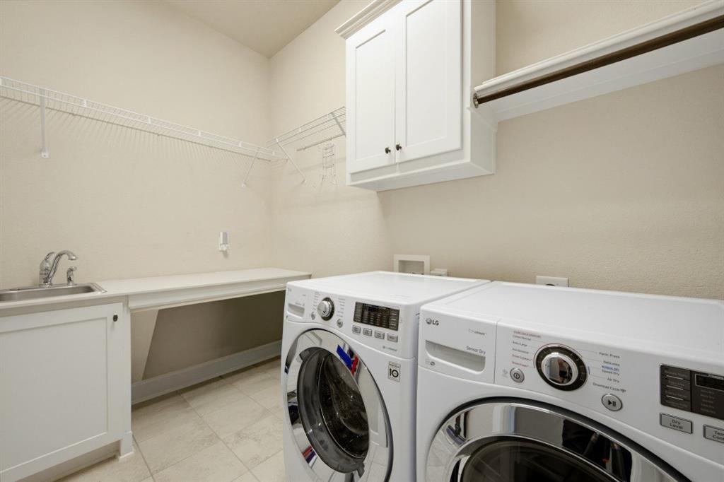 2721 Old Shire Path Road Prosper, TX 75078 - Photo 15 of 39 Laundry room featuring a stainless steel sink, built-in lower cabinetry, a built-in folding counter, upper cabinetry, and wire shelving