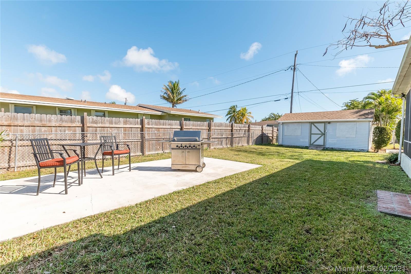 19931 Dothan Road Cutler Bay, FL 33157 - Photo 11 of 27 a view of a swimming pool with a lawn chairs and floor to ceiling window