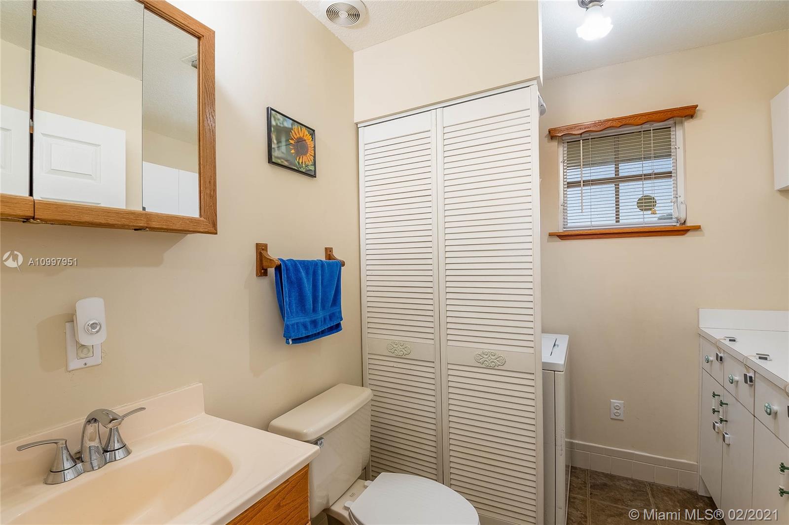 19931 Dothan Road Cutler Bay, FL 33157 - Photo 19 of 27 a bathroom with a toilet sink and mirror