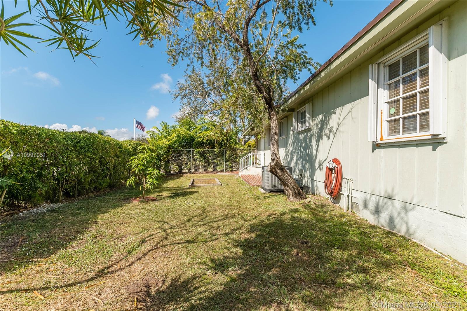 19931 Dothan Road Cutler Bay, FL 33157 - Photo 27 of 27 a backyard of a house with large trees and plants