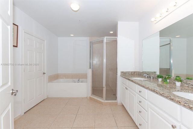 a spacious bathroom with a granite countertop tub sink and mirror