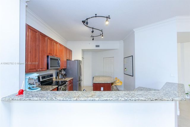 a kitchen with stainless steel appliances granite countertop a sink and a refrigerator