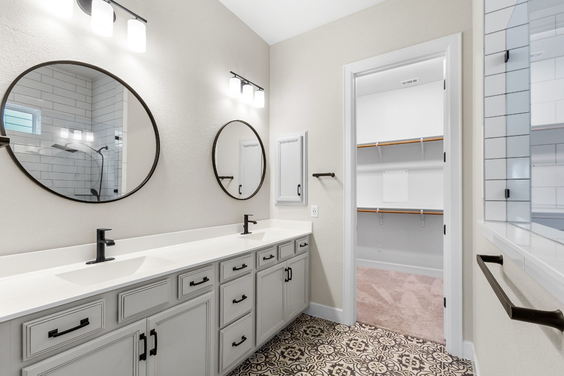 1046 Hazy Hills Loop Dripping Springs, TX 78620 - Photo 12 of 35 a bathroom with a double vanity sink and a mirror