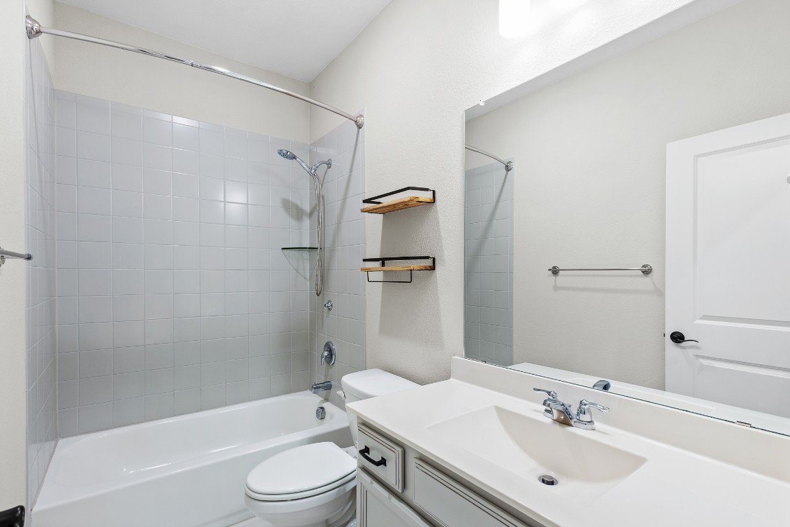 1046 Hazy Hills Loop Dripping Springs, TX 78620 - Photo 25 of 35 a bathroom with a sink a toilet and shower