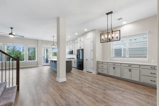 a view of a kitchen center island wooden floor and a ceiling fan