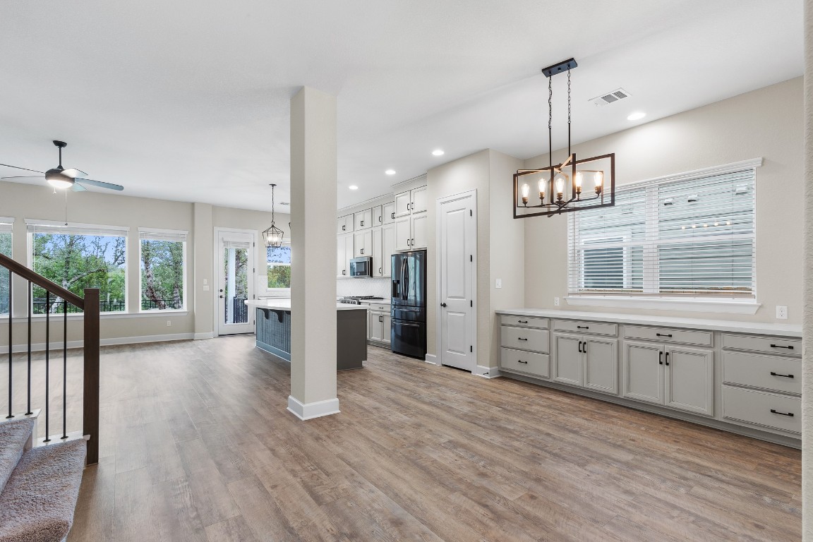 1046 Hazy Hills Loop Dripping Springs, TX 78620 - Photo 3 of 35 a view of a kitchen with wooden floor and a window