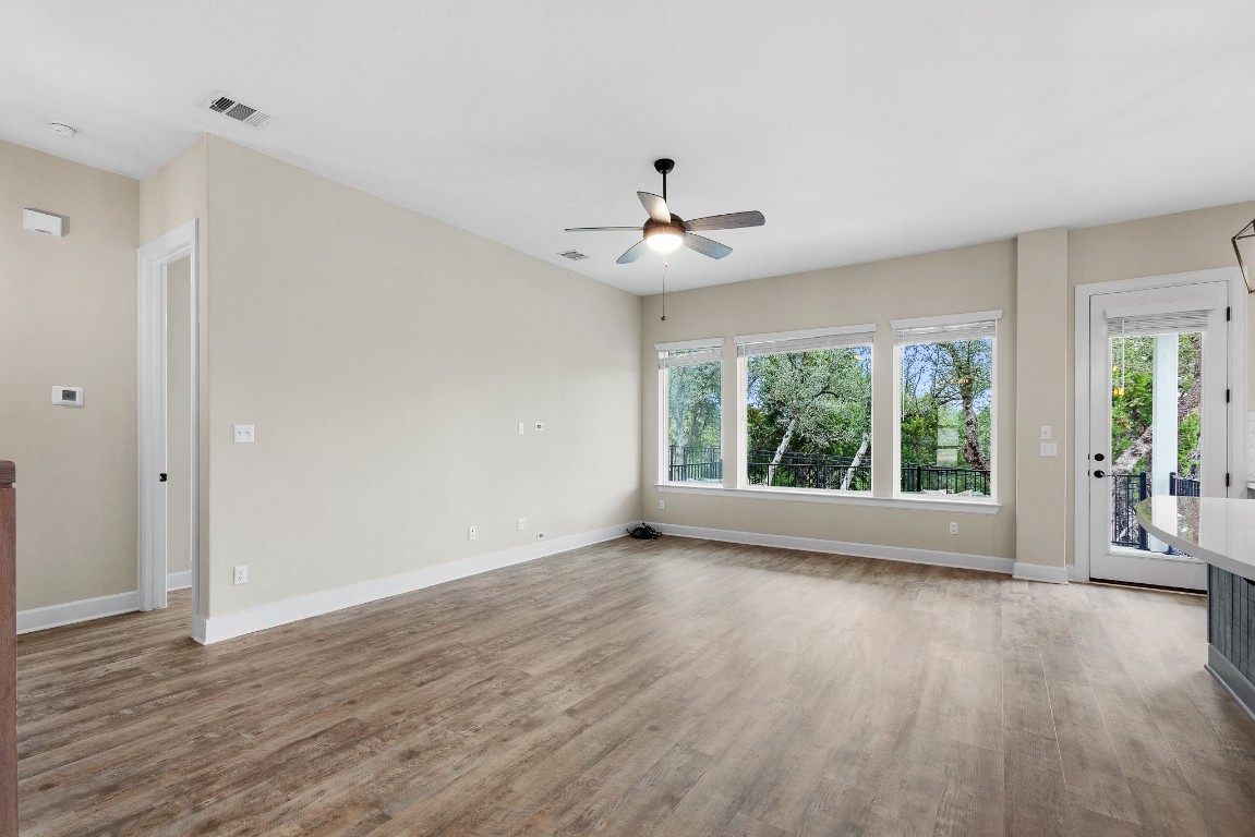 1046 Hazy Hills Loop Dripping Springs, TX 78620 - Photo 5 of 35 a view of an empty room with wooden floor and a window
