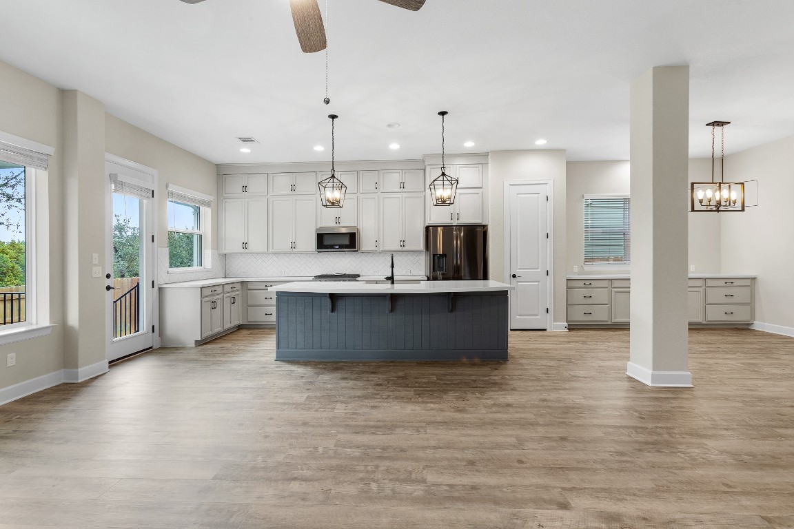 1046 Hazy Hills Loop Dripping Springs, TX 78620 - Photo 35 of 35 a large kitchen with stainless steel appliances kitchen island granite countertop a large counter top and a view of living room