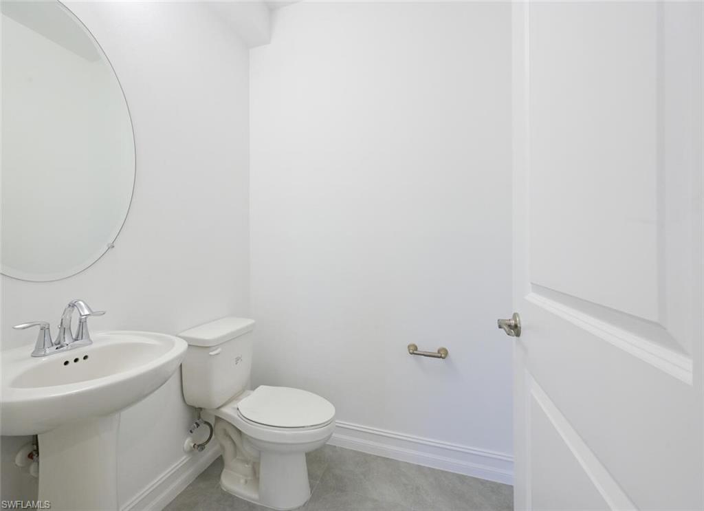 7611 Morgan Way Naples, FL 34119 - Photo 8 of 26 a bathroom with a sink toilet and a mirror
