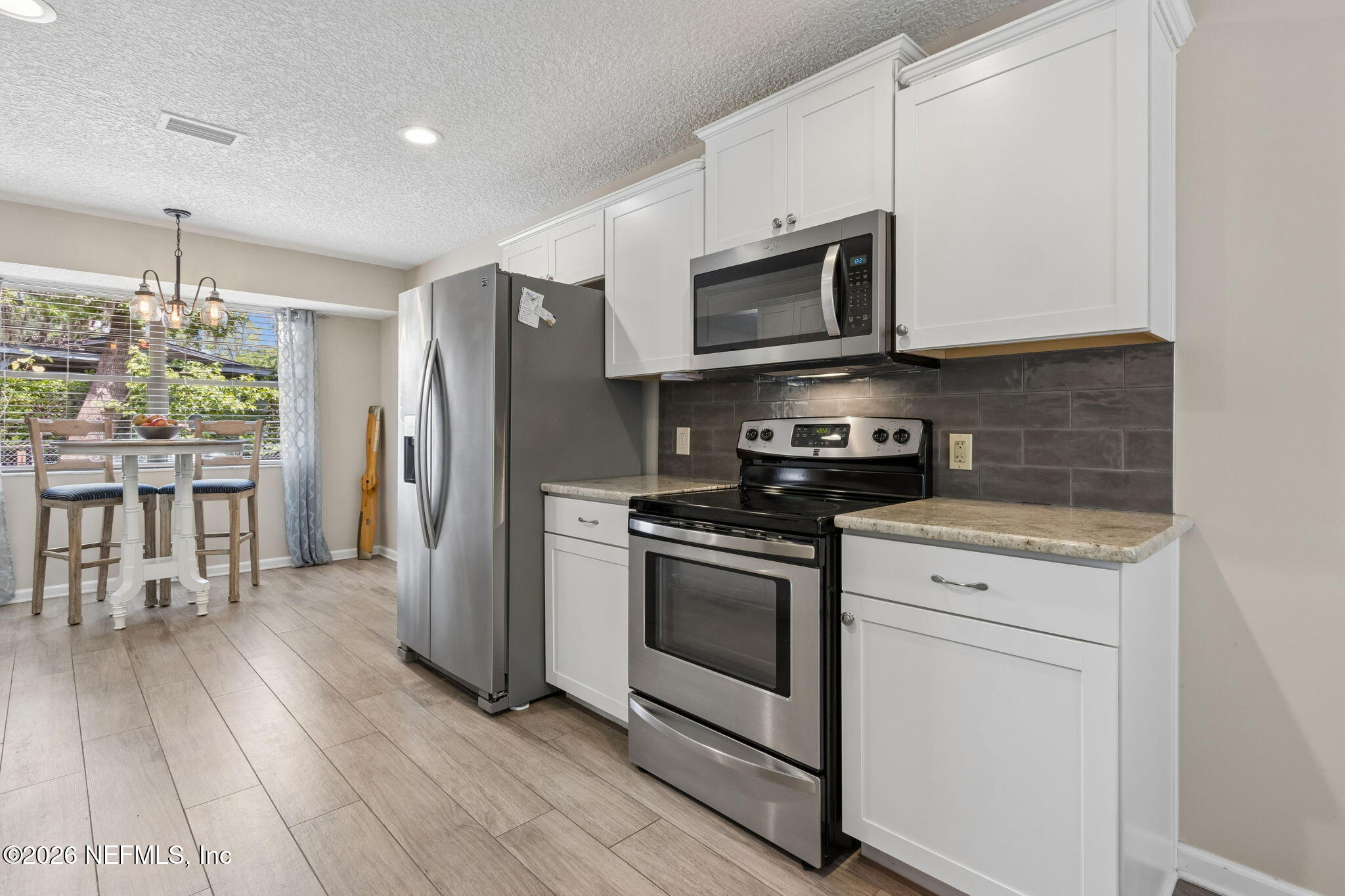 3194 Creighton Landing Road Fleming Island, FL 32003 - Photo 14 of 31 a kitchen with stainless steel appliances granite countertop a stove a microwave and a hard wood floors