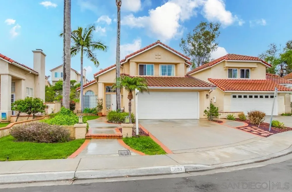 a front view of a house with garage and parking