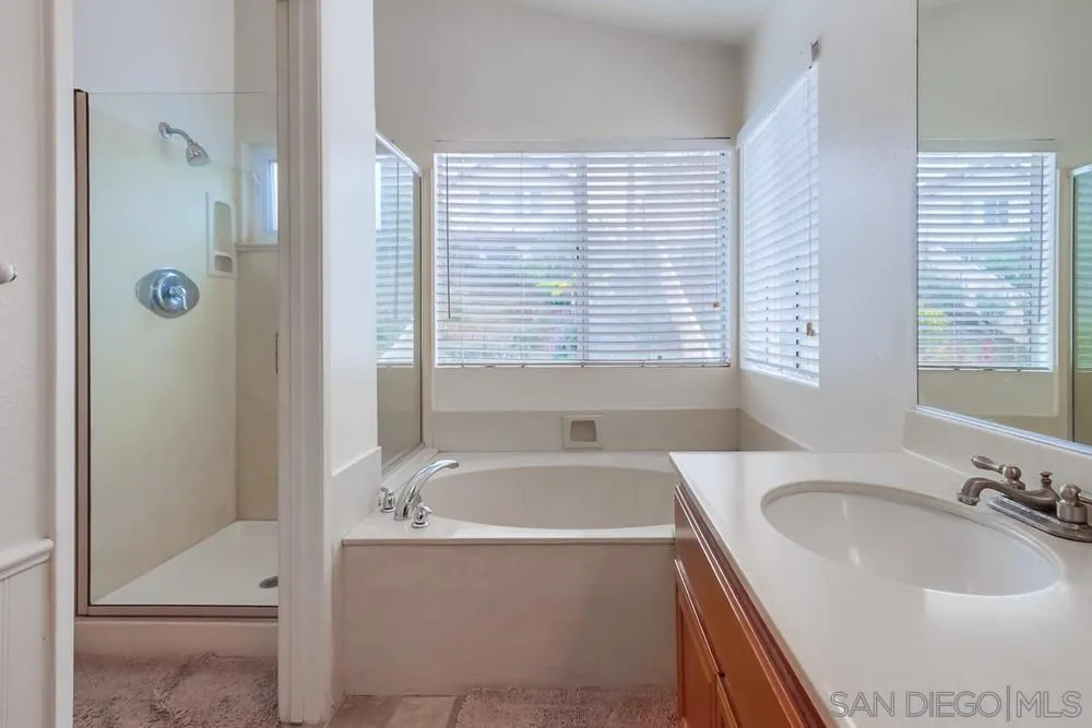 1507 Promontory Ridge Way Vista, CA 92081 - Photo 16 of 28 a bathroom with a granite countertop tub sink and mirror