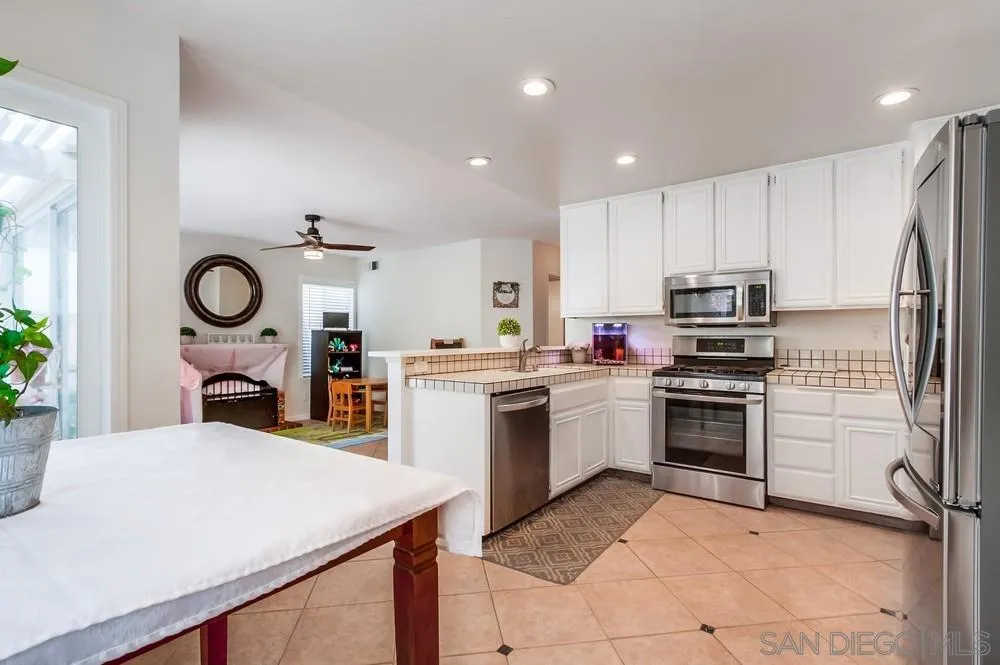 1507 Promontory Ridge Way Vista, CA 92081 - Photo 9 of 28 a kitchen with a refrigerator a stove top oven and a sink