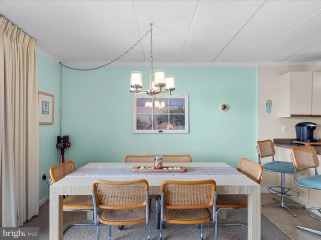 a kitchen with stainless steel appliances granite countertop a refrigerator a sink a stove a dining table and chairs with wooden floor