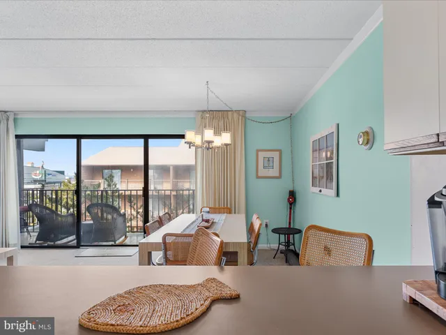 a kitchen with stainless steel appliances granite countertop a refrigerator a sink a stove a dining table and chairs