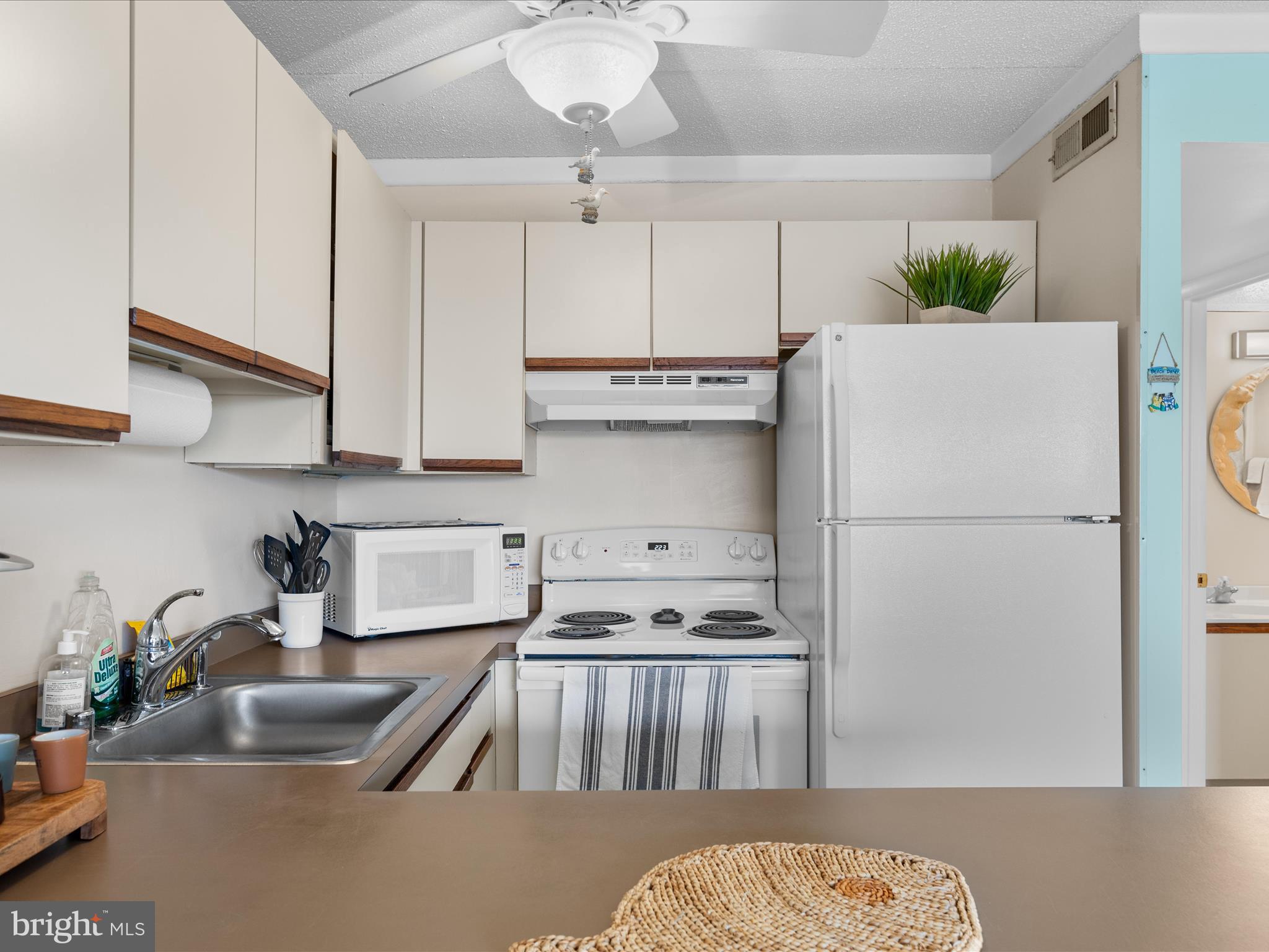 17 70th Street, Unit 25 Ocean City, MD 21842 - Photo 15 of 37 a kitchen with stainless steel appliances granite countertop a refrigerator a sink a stove a dining table and chairs