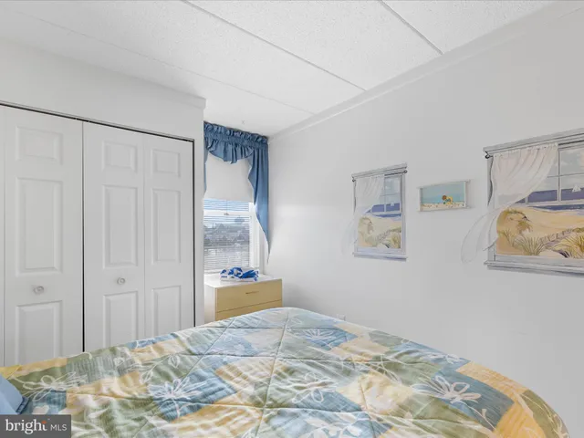 a bedroom with a bed and painting on the wall