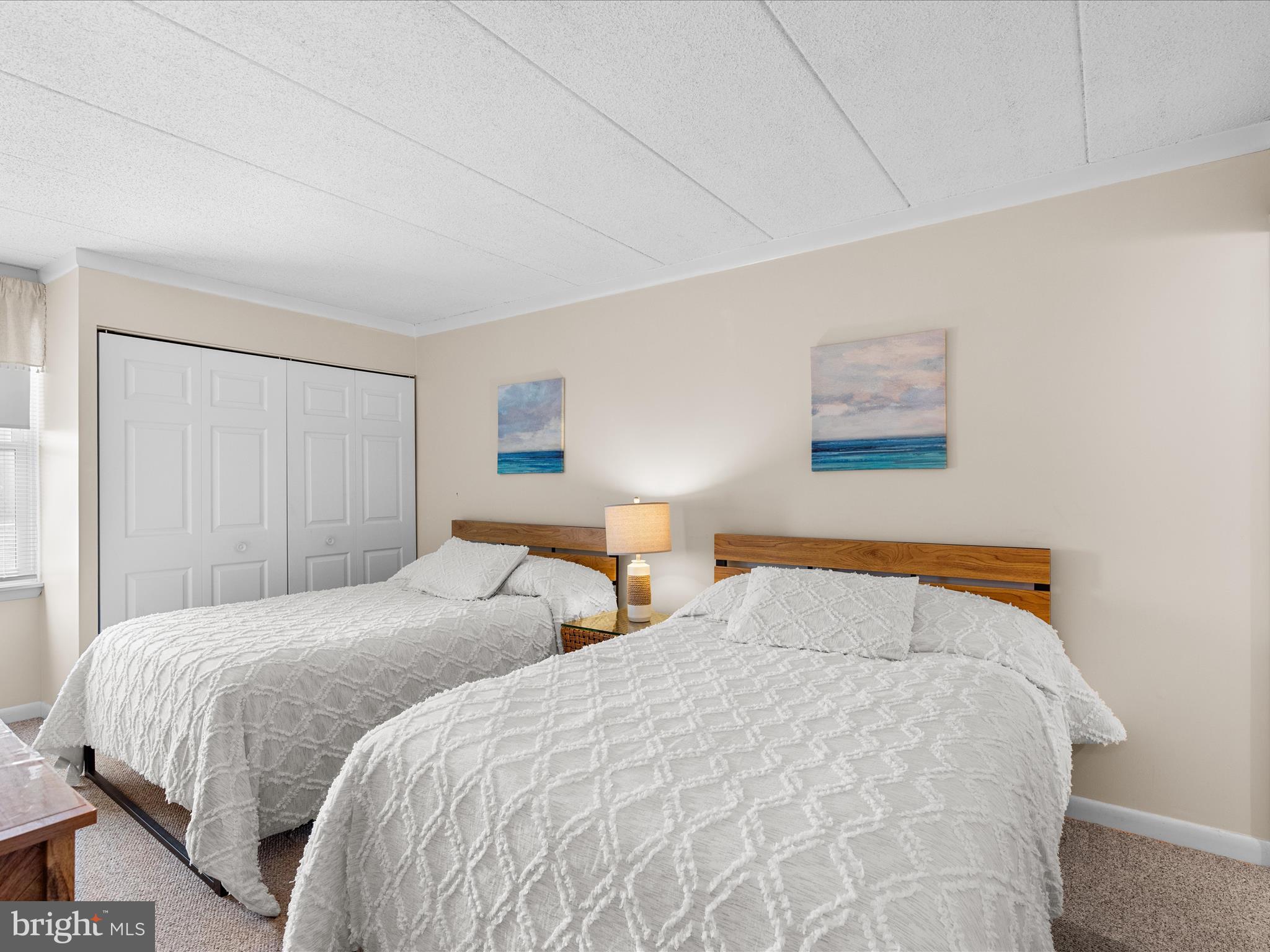 17 70th Street, Unit 25 Ocean City, MD 21842 - Photo 23 of 37 a bedroom with two beds and a night stand
