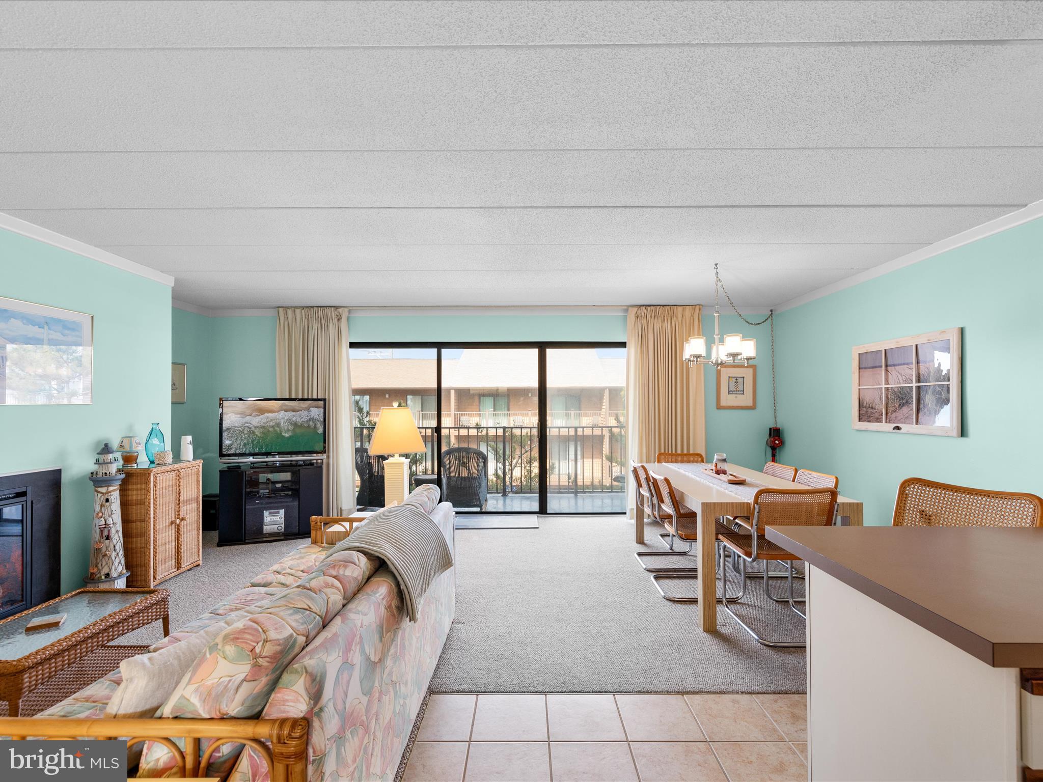 17 70th Street, Unit 25 Ocean City, MD 21842 - Photo 8 of 37 a living room with furniture large window and a flat screen tv