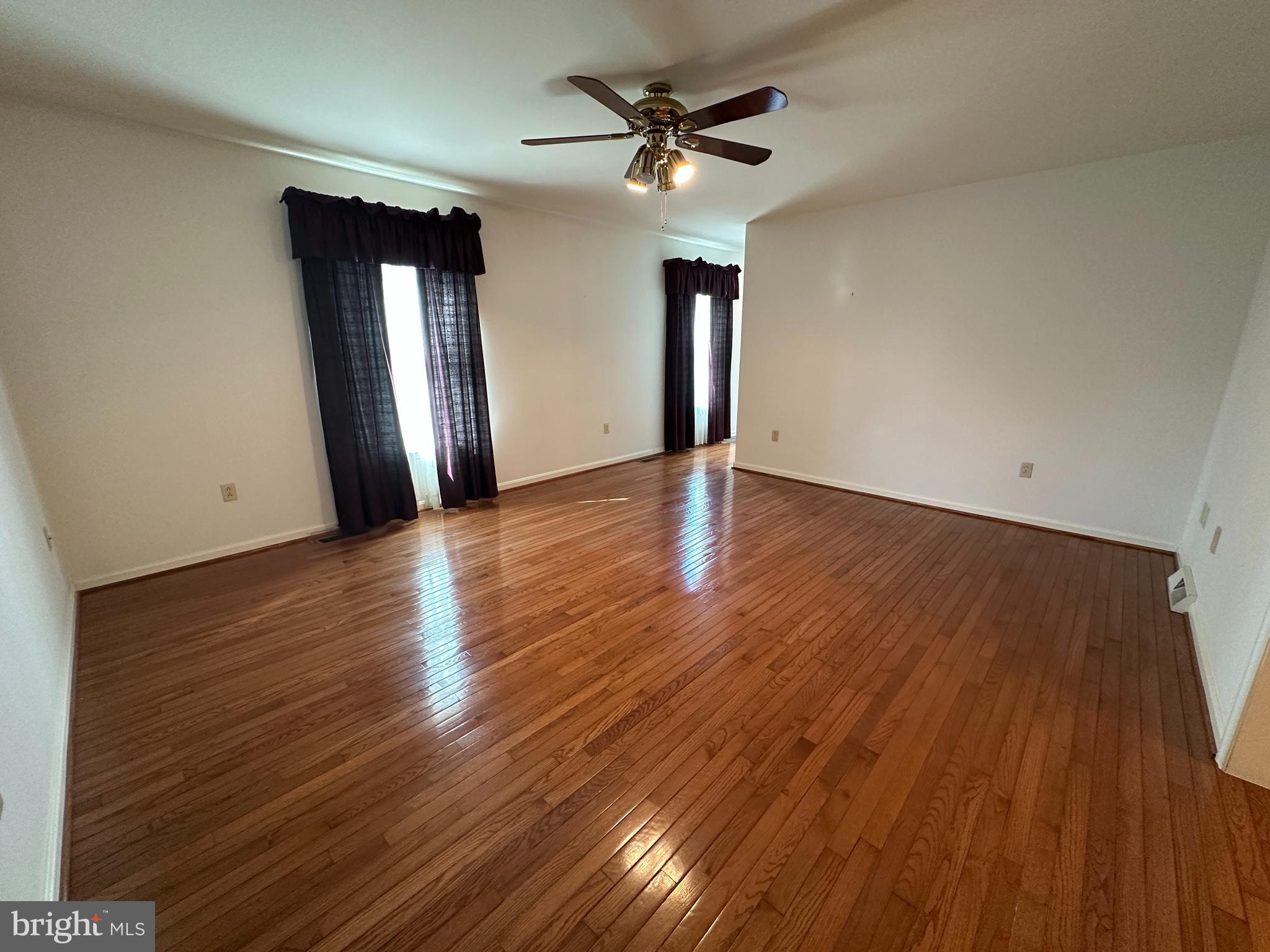10744 Apple Tree Lane Williamsport, MD 21795 - Photo 53 of 118 a view of an empty room with wooden floor and a ceiling fan