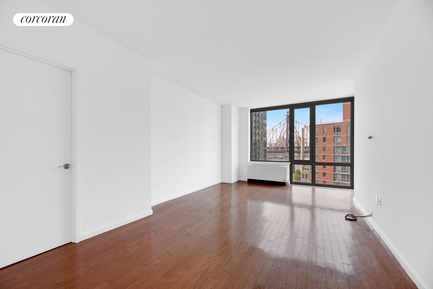 455 Main Street, Unit 16A Manhattan, NY 10044 - Photo 10 of 18 a view of an empty room with wooden floor and a window