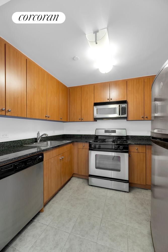 455 Main Street, Unit 16A Manhattan, NY 10044 - Photo 9 of 18 a kitchen with stainless steel appliances granite countertop a stove and a sink