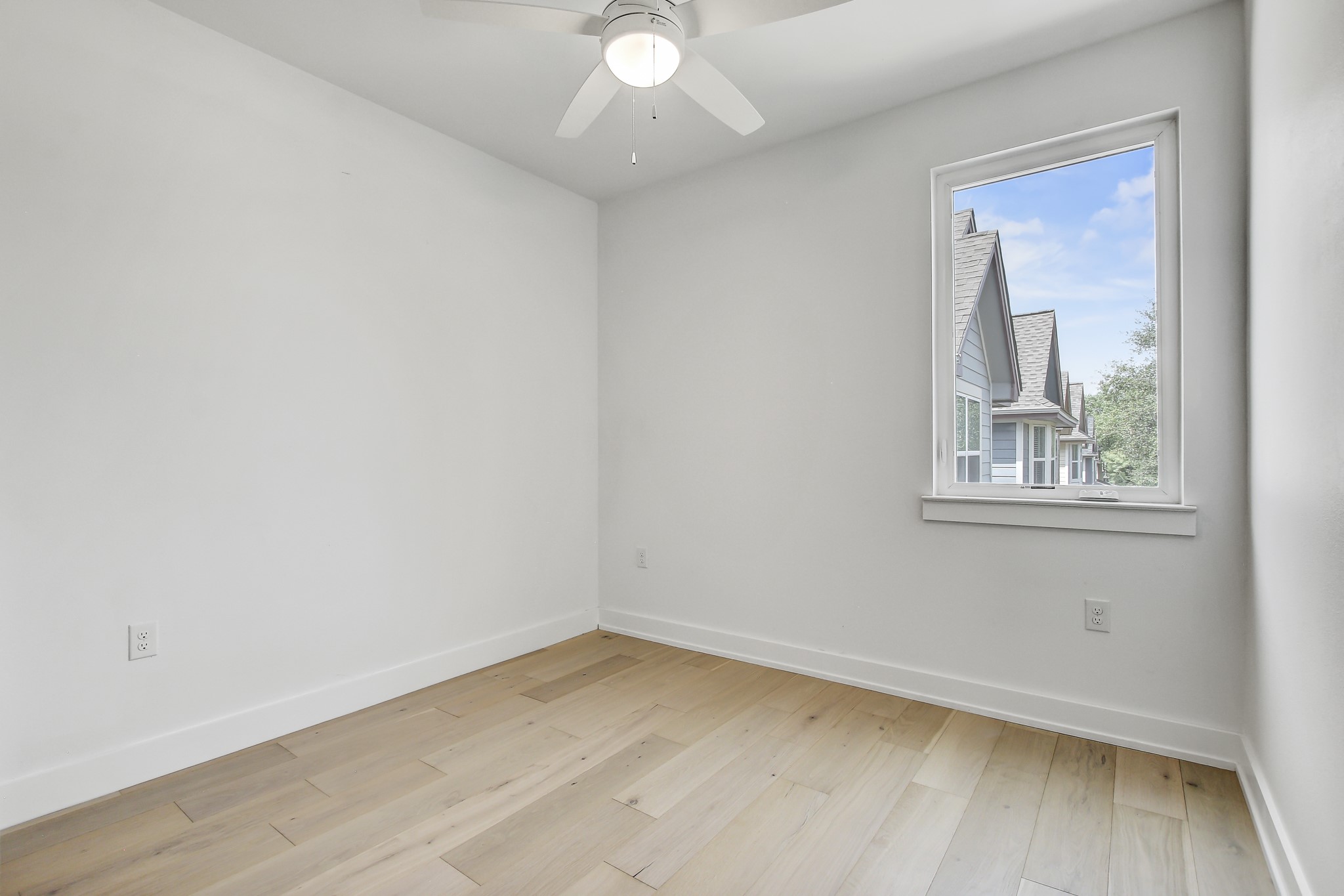 4127 East 12th Street, Unit 3 Austin, TX 78721 - Photo 6 of 29 Empty room featuring light wood finished floors and baseboards