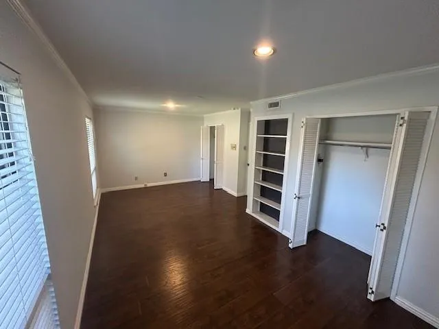 an empty room with wooden floor and window