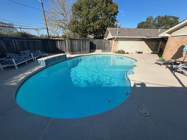 a view of a backyard with potted plants and wooden fence