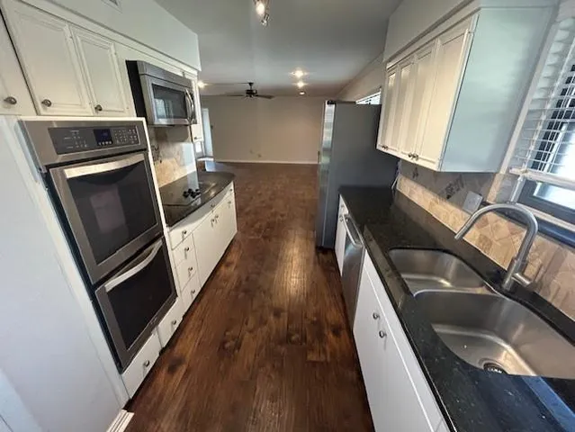 a kitchen with a sink a microwave a stove and refrigerator