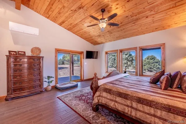 a bedroom with furniture wooden floor and window