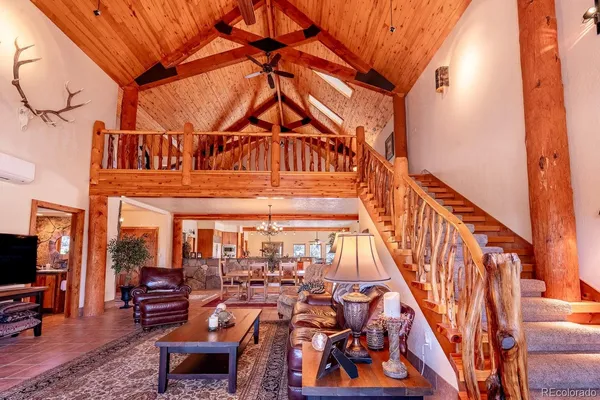 a living room with furniture stairs and a rug
