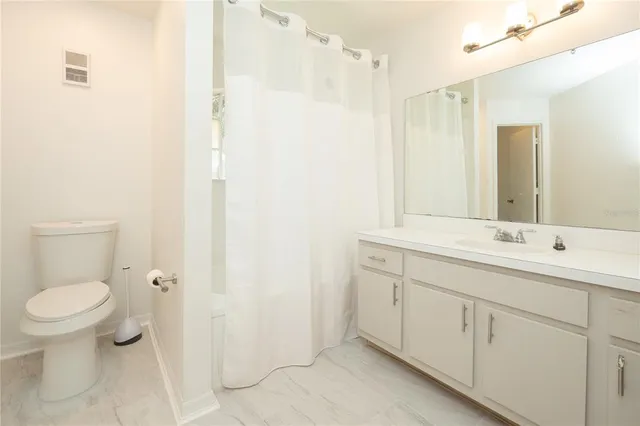 a bathroom with a double vanity sink toilet and a mirror
