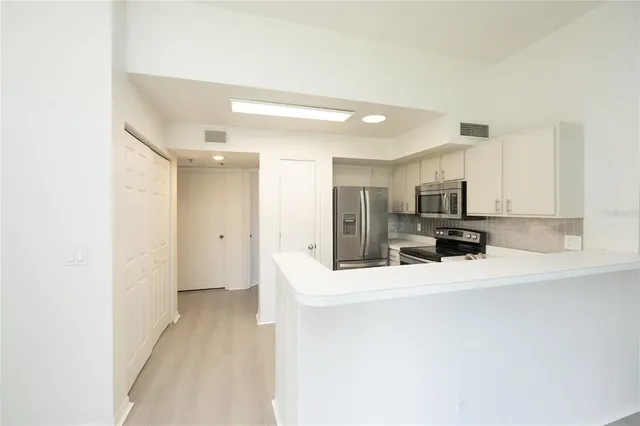 a view of a kitchen with a sink and a refrigerator