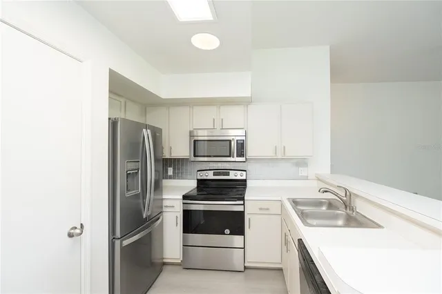 a kitchen with a refrigerator sink and stove top oven