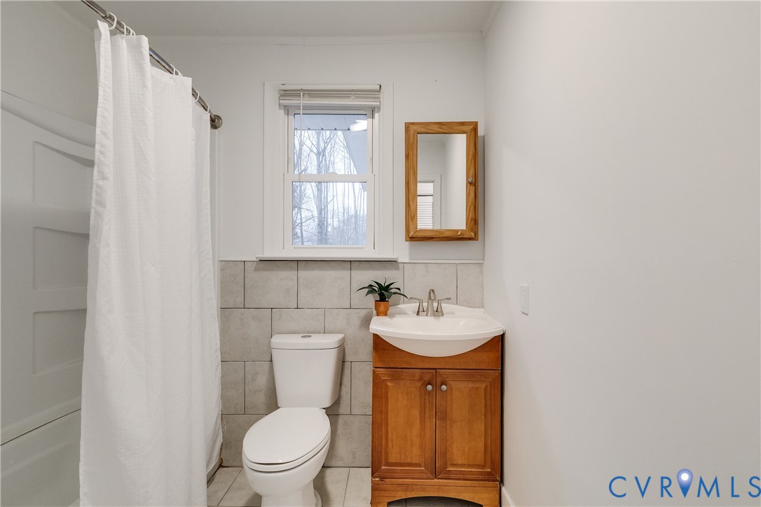 763 Oak Spring Lane Manakin-Sabot, VA 23103 - Photo 16 of 25 a bathroom with a toilet a sink and a window