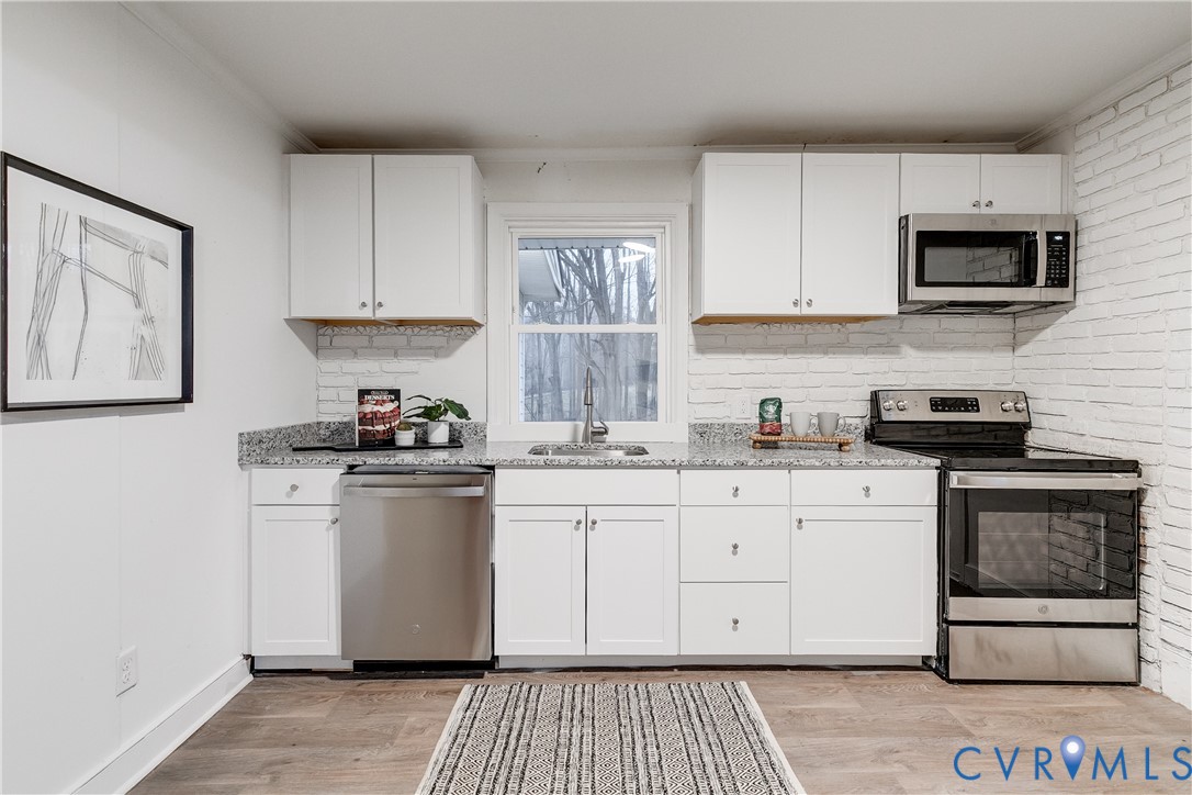 763 Oak Spring Lane Manakin-Sabot, VA 23103 - Photo 10 of 25 a kitchen with stainless steel appliances granite countertop a stove a sink and a microwave