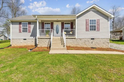 a view of a house with backyard and a garden